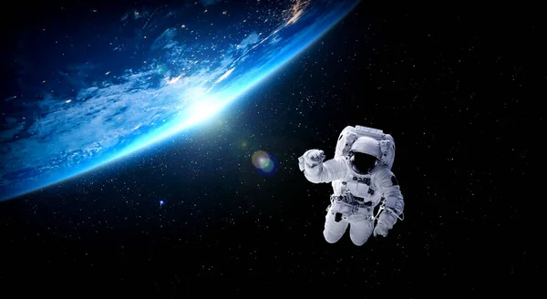 宇宙飛行士は宇宙ステーションで働いている間に宇宙遊泳をします — ストック写真