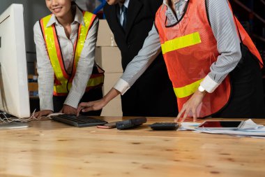 Depo müdürü ve işçisi depoda çalışıyor.