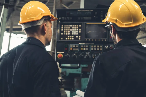 Gruppo di operai qualificati che utilizzano attrezzature per macchine in officina — Foto Stock