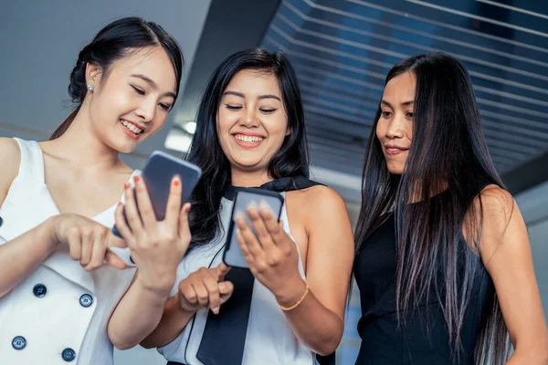 Drei Freundinnen chatten mit Mobiltelefon. — Stockfoto