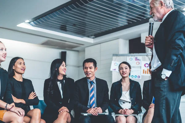 Senior leider spreker spreekt tot mensen publiek. — Stockfoto