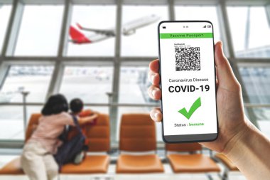 Gezgin COVID 19 aşı durumunu göstermek için aşı pasaport sertifikasına sahip.