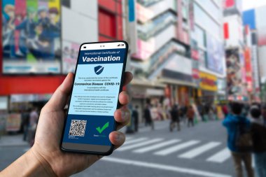 Gezgin COVID 19 aşı durumunu göstermek için aşı pasaport sertifikasına sahip.