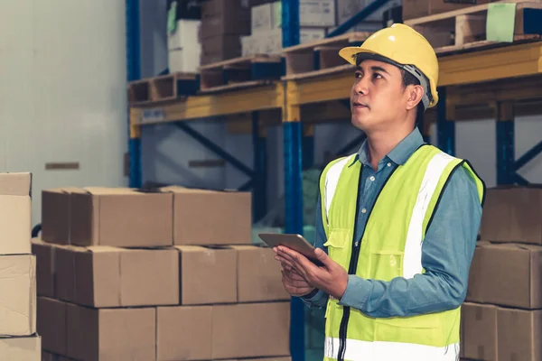 Asian warehouse worker checking packages in storehouse — Stock Photo, Image