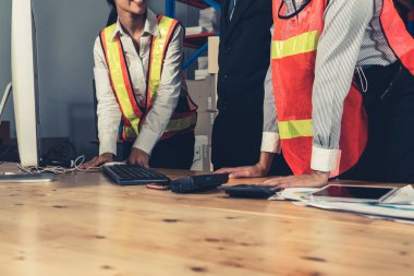 Depo müdürü ve işçisi depoda çalışıyor.