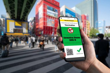 Gezgin COVID 19 aşı durumunu göstermek için aşı pasaport sertifikasına sahip.
