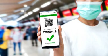 Gezgin COVID 19 aşı durumunu göstermek için aşı pasaport sertifikasına sahip.