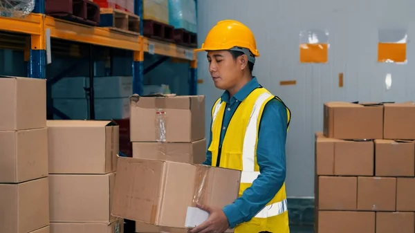 Asiatischer Lagerarbeiter überprüft Pakete in Lagerhalle — Stockfoto