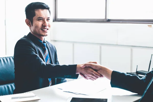 Business people handshake agreement in office.