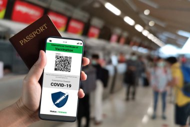 Gezgin COVID 19 aşı durumunu göstermek için aşı pasaport sertifikasına sahip.