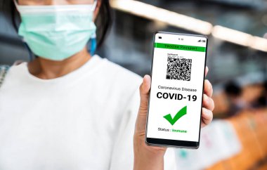 Gezgin COVID 19 aşı durumunu göstermek için aşı pasaport sertifikasına sahip.