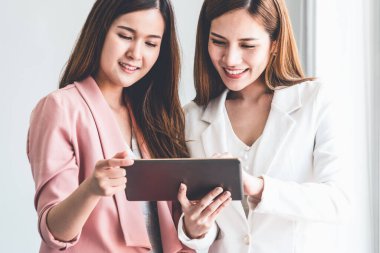 Ofiste tablet bilgisayar kullanan iş kadınları.