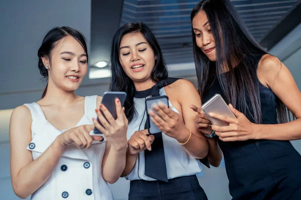 Tres mujeres amigos chatear con el dispositivo de teléfono móvil. —  Fotos de Stock