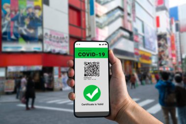 Gezgin COVID 19 aşı durumunu göstermek için aşı pasaport sertifikasına sahip.