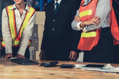 Depo müdürü ve işçisi depoda çalışıyor.