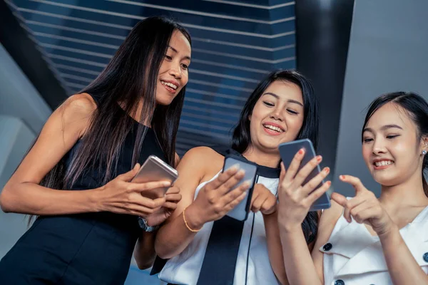 Tres mujeres amigos chatear con el dispositivo de teléfono móvil. —  Fotos de Stock