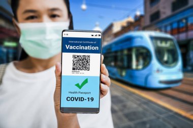 Gezgin COVID 19 aşı durumunu göstermek için aşı pasaport sertifikasına sahip.