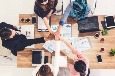 Takım çalışması çalışanları toplantıda el ele tutuşuyor.