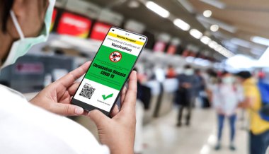 Gezgin COVID 19 aşı durumunu göstermek için aşı pasaport sertifikasına sahip.
