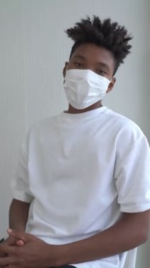 Genç Afrikalı adamın yüzünden maskesini çıkardığı dikey video.