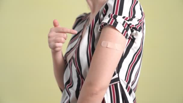 Mujer joven con vendaje de vacuna COVID-19 alegremente — Vídeos de Stock