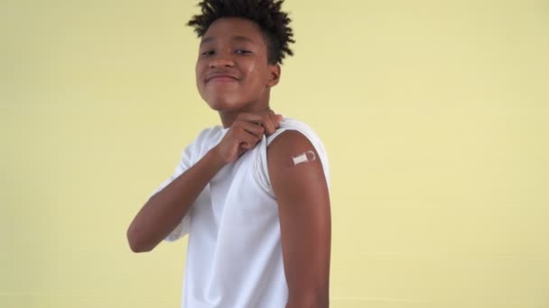 Adolescente afroamericano che mostra allegramente la fasciatura del vaccino COVID-19 — Video Stock