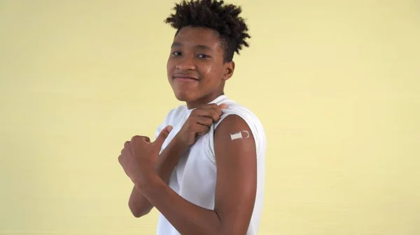 Afrikansk amerikansk tonåring visar COVID-19 vaccin bandage glatt — Stockfoto