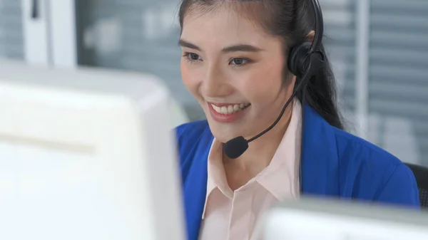Vezetékes fülhallgatót viselő üzletasszony aktívan dolgozik az irodában — Stock Fotó