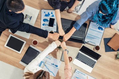 Takım çalışması çalışanları toplantıda el ele tutuşuyor.