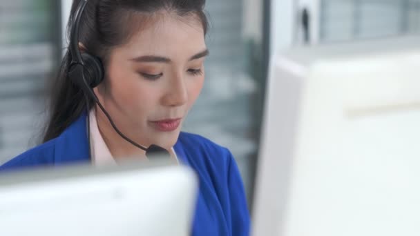 Empresaria con auriculares trabajando activamente en la oficina — Vídeos de Stock