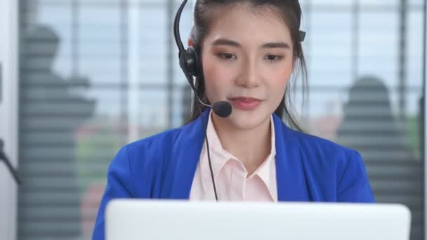 Empresaria con auriculares trabajando activamente en la oficina — Vídeos de Stock