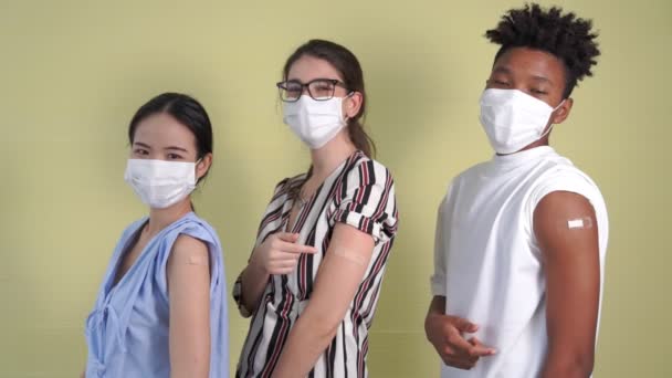 Vielfältige Gruppe von Menschen zeigt fröhlich COVID-19 Impfverband — Stockvideo