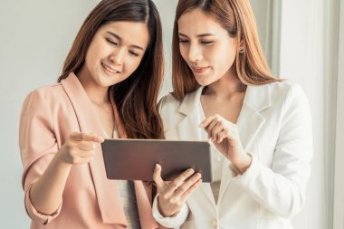 Ofiste tablet bilgisayar kullanan iş kadınları.