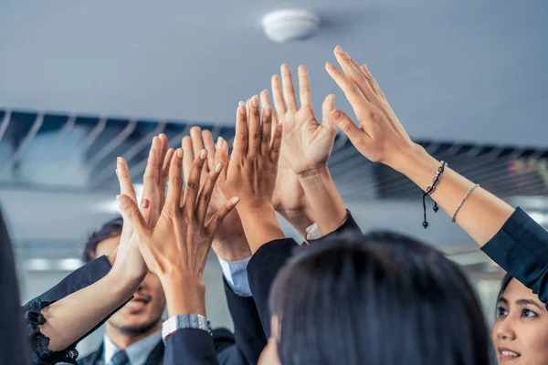 Muchos empresarios felices levantan las manos juntos. — Foto de Stock