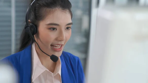 Vezetékes fülhallgatót viselő üzletasszony aktívan dolgozik az irodában — Stock Fotó