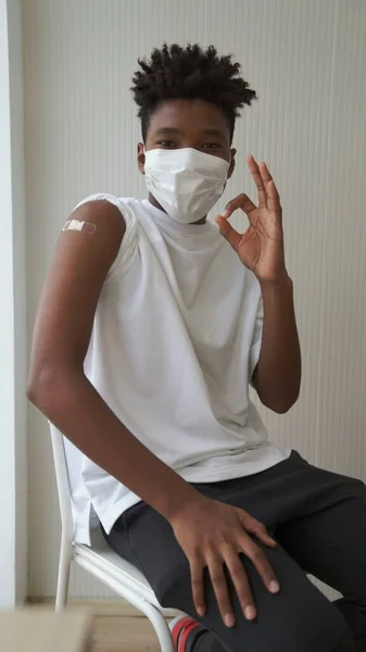 African American teenager showing COVID-19 vaccine bandage merrily — Stock Photo, Image