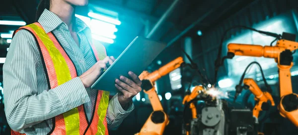 Ingeniero utiliza software robótico avanzado para controlar brazo robot de la industria en fábrica — Foto de Stock