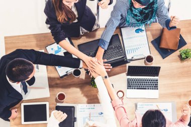 Takım çalışması çalışanları toplantıda el ele tutuşuyor.