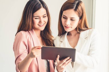 Ofiste tablet bilgisayar kullanan iş kadınları.