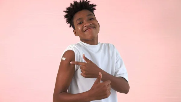 African American teenager showing COVID-19 vaccine bandage merrily — Stock Photo, Image