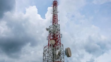 Gökyüzüne ve arkaplandaki bulutlara karşı telekomünikasyon kulesinin zaman atlaması