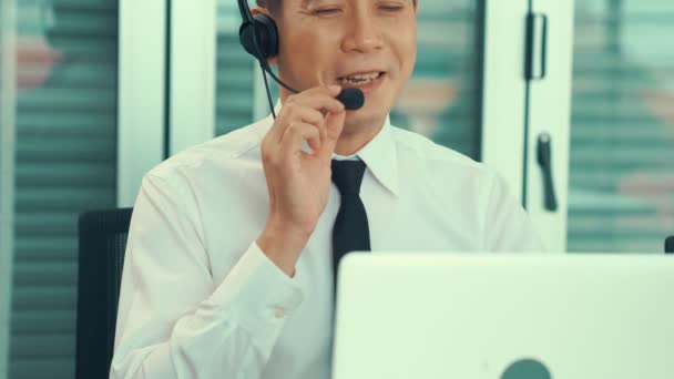Fejhallgatót viselő üzletember, aki aktívan dolgozik az irodában — Stock videók