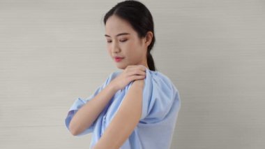 Genç Asyalı kadın COVID-19 aşısını neşeyle gösteriyor.