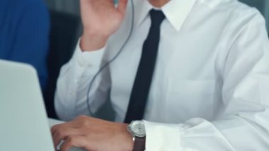 Kulaklık takan iş adamları ofiste aktif olarak çalışıyorlar.