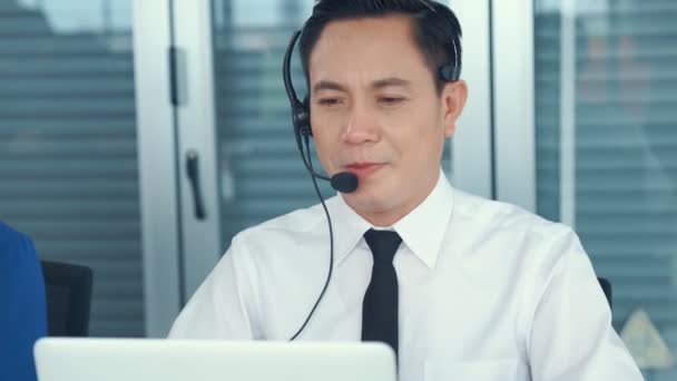 Empresario con auriculares trabajando activamente en la oficina — Vídeos de Stock
