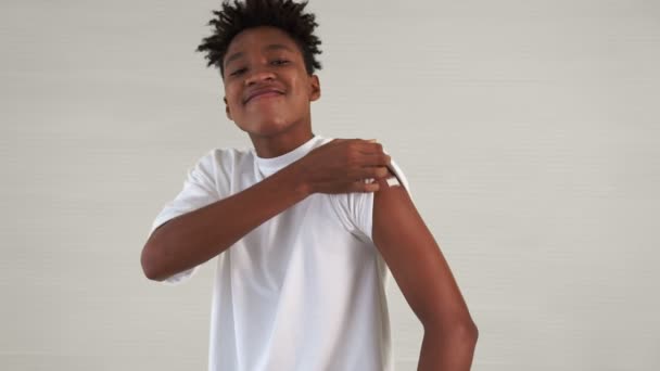 African American nastolatek pokazując COVID-19 szczepionka bandaż wesoło — Wideo stockowe