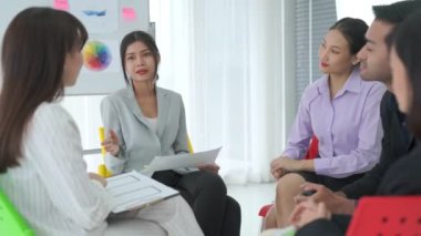 İş adamları daire içinde otururken iş projesini ustaca tartışıyor
