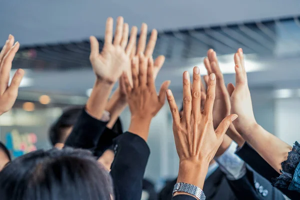 Muitas pessoas de negócios felizes levantam as mãos juntas. — Fotografia de Stock