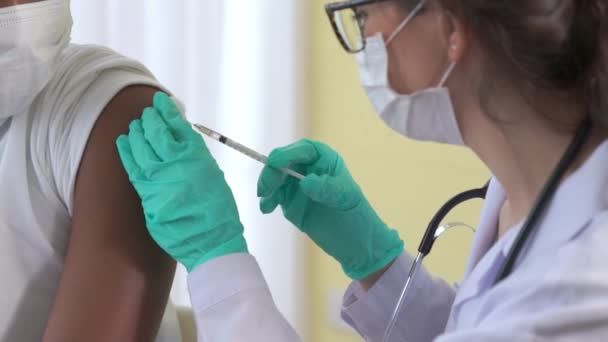 Un jeune homme consulte un médecin habile à l'hôpital pour se faire vacciner — Video