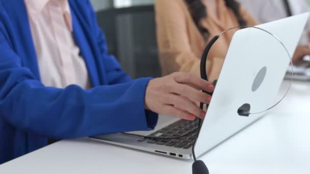 Mulher de negócios usando fone de ouvido trabalhando ativamente no escritório — Vídeo de Stock